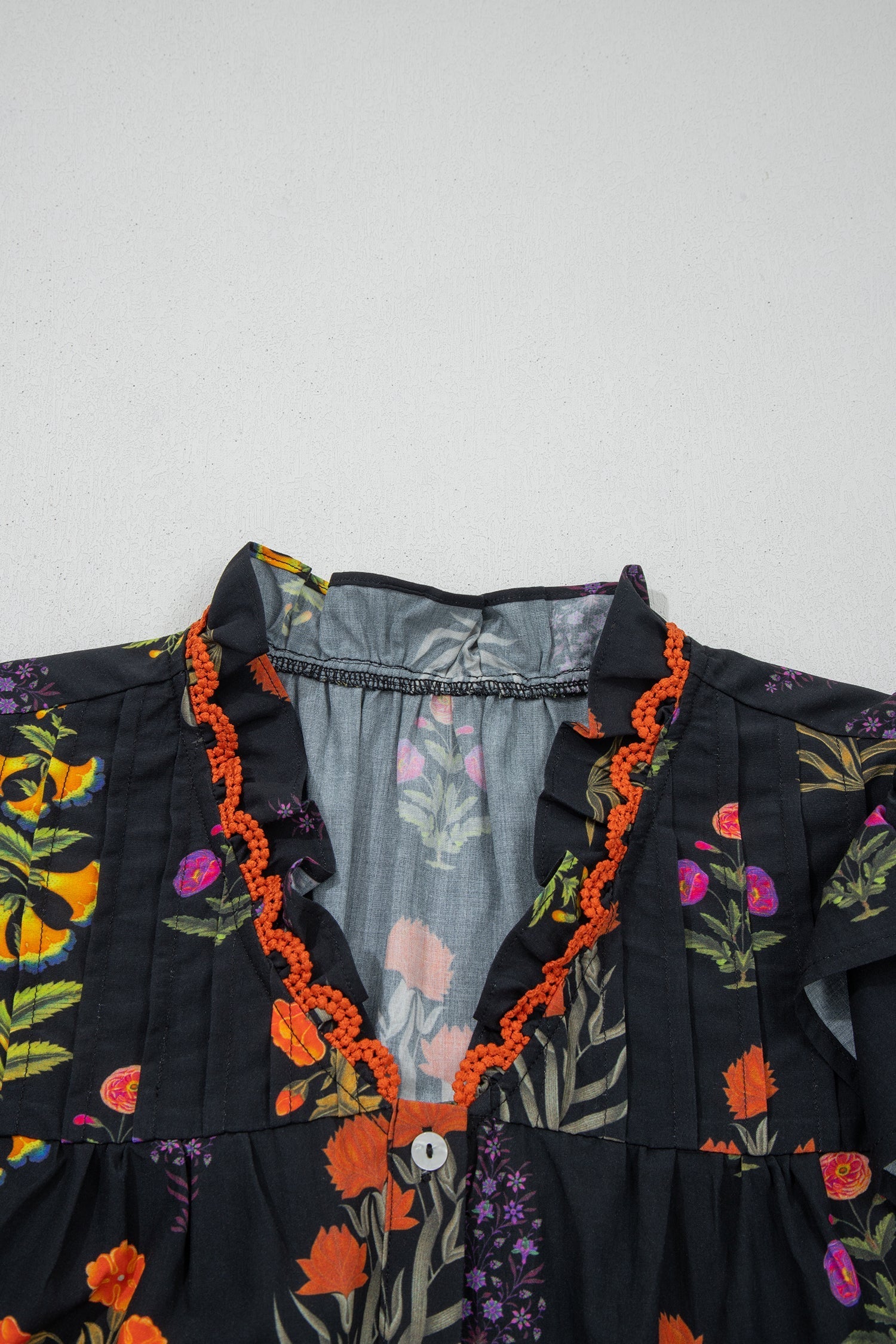 Chemise noire à fleurs avec bordure en dentelle et décolleté en V à volants