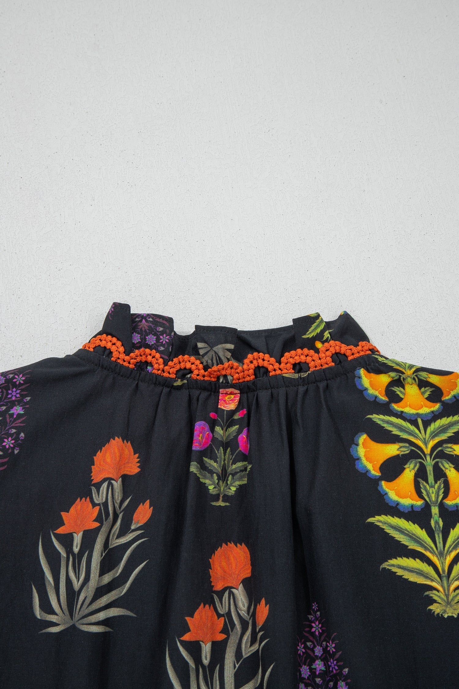 Chemise noire à fleurs avec bordure en dentelle et décolleté en V à volants