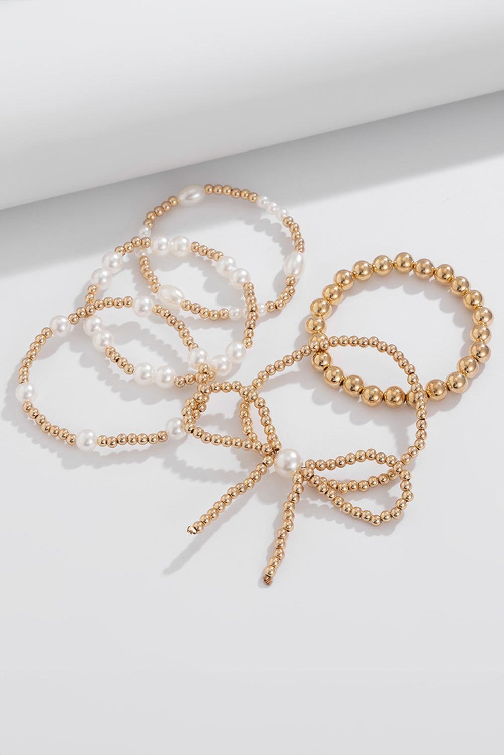Set di Bracciali Multistrato con Fiocco Dorato e Perle