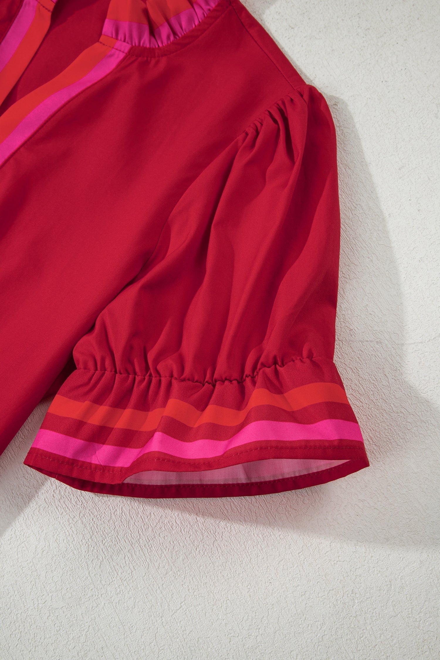 Flame-red striped blouse with a ruffled collar and short puff sleeves